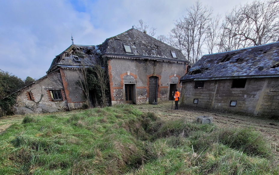 Géomètre d'OMETSA en train de mesurer un site qui a été détruit par un évènement climatique